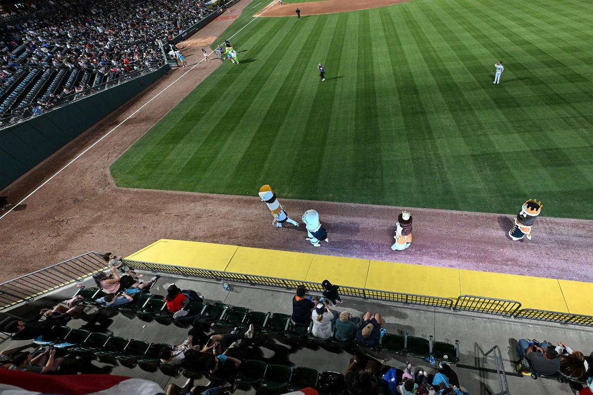 Fans watch mascots race along the warning track during a Minor League Baseball game between the Charlotte Knights and Gwinnett Stripers at Truist Field, Friday, March 28, 2025, in Charlotte, N.C. (Charlotte Observer/Matt Kelley)