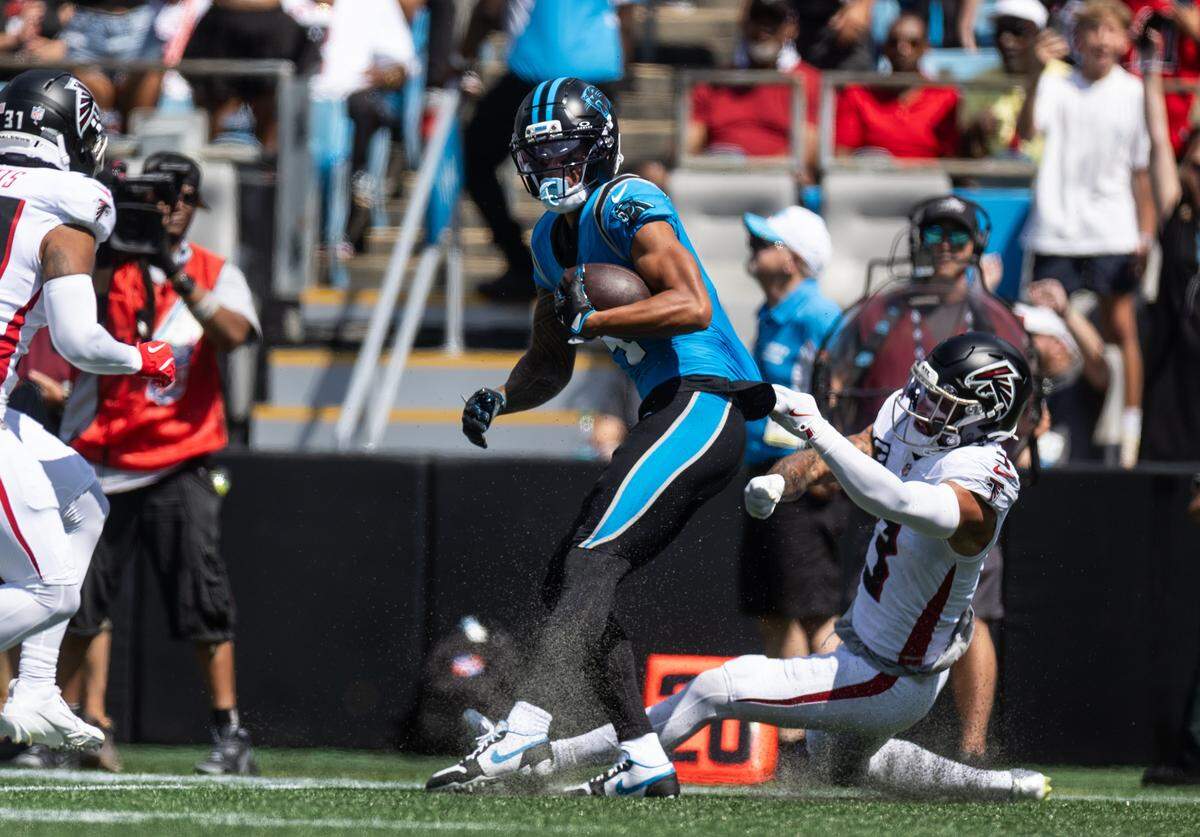 Carolina Panthers wide receiver Tetairoa McMillan, left, is pulled down by Atlanta Falcons free safety Jessie Bates at the Bank of America Stadium in Charlotte, N.C., on Sunday, September 21, 2025.