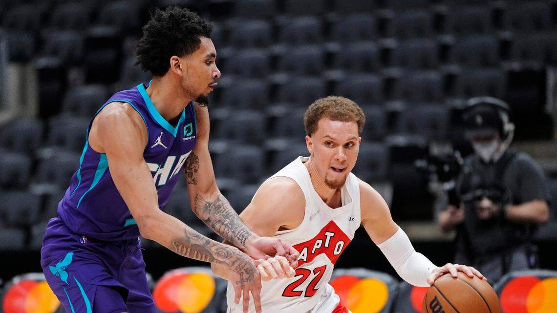 Toronto Raptors guard Malachi Flynn (22) drives around Charlotte Hornets guard James Bouknight (5) during the first half of an NBA basketball game in Toronto, Tuesday, Jan. 25, 2022. (Frank Gunn/The Canadian Press via AP)