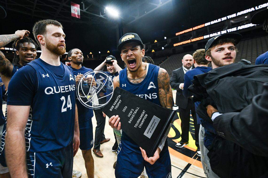 Nasir Mann (center, with trophy) celebrates with his Queens teammates after the Royals made it to the NCAA tournament for the first time with a win in the Atlantic Sun championship game over Central Arkansas on Sunday, March 8, 2026, in Jacksonville, Fla.
