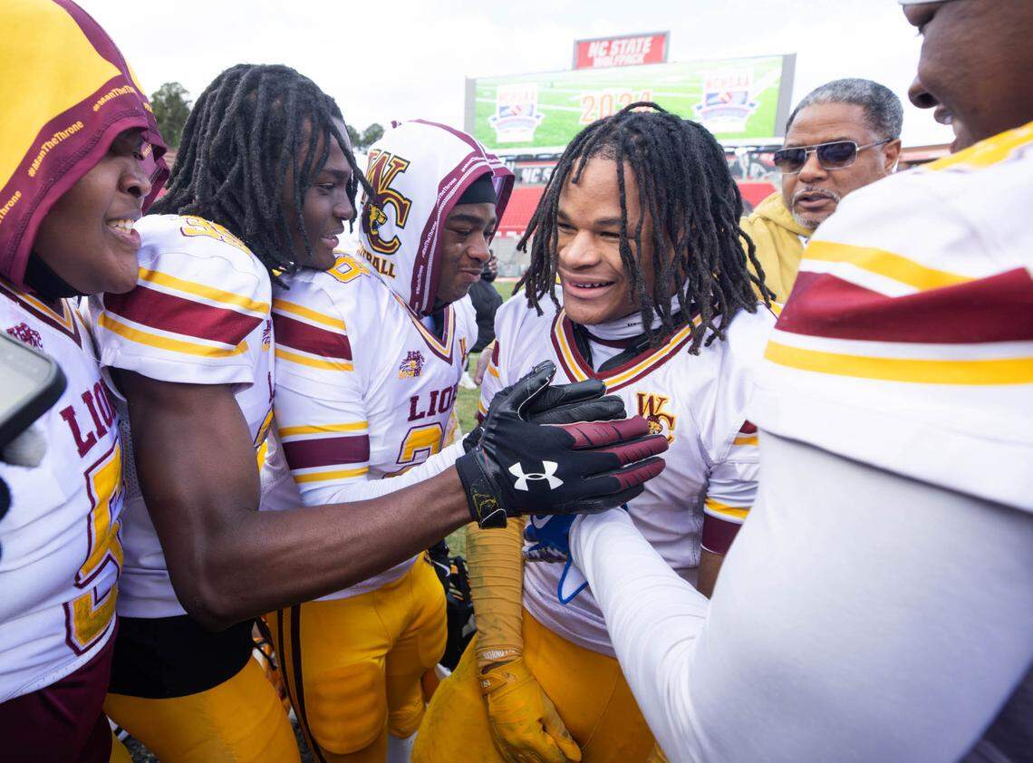West Charlotte teammates celebrate with Noah Colllins (center). West Charlotte would defeat  Seventy-First 17-14 in the NCHSAA 3A state championship game at Carter Finley Stadium Saturday December 21, 2024.