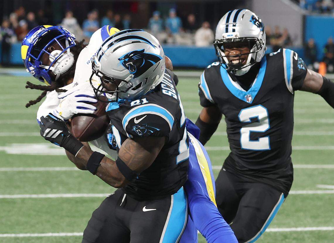 Carolina Panthers safety Nick Scott, center, makes the tackle on Los Angeles Rams wide receiver Davante Adams, left, during action at Bank of America Stadium on Saturday, January 10, 2026. Scott was give a penalty on the play. The Rams defeated the Panthers 34-31.