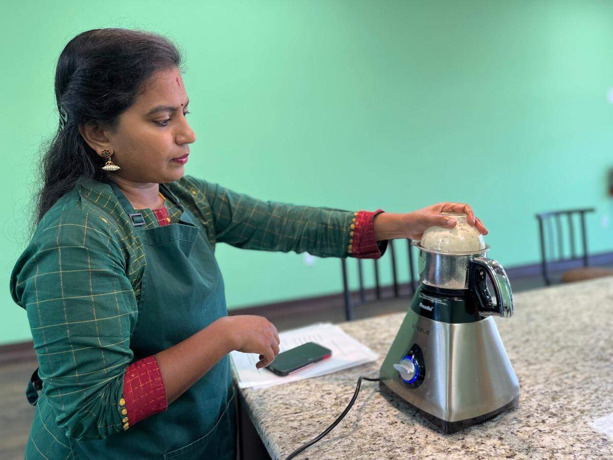 Santhoshi Radhakrishnan uses a high-speed blender from India to make the garlic and ginger paste for her recipes in her Tega Cay cooking studio.