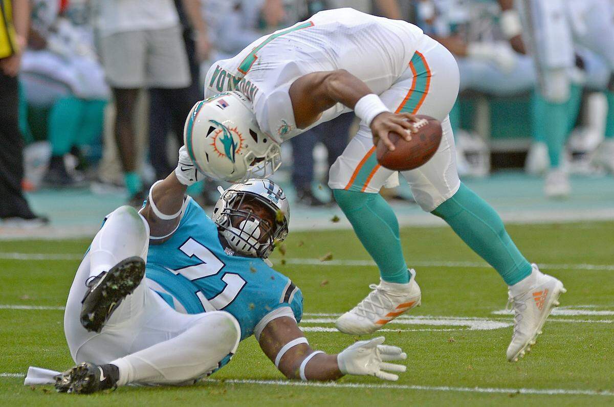 Carolina Panthers defensive tackle Phil Hoskins, left, sacks Miami Dolphins quarterback Tua Tagovailoa, right, during second quarter action at Hard Rock Stadium in Miami Gardens, Fla. on Sunday, November 28, 2021.