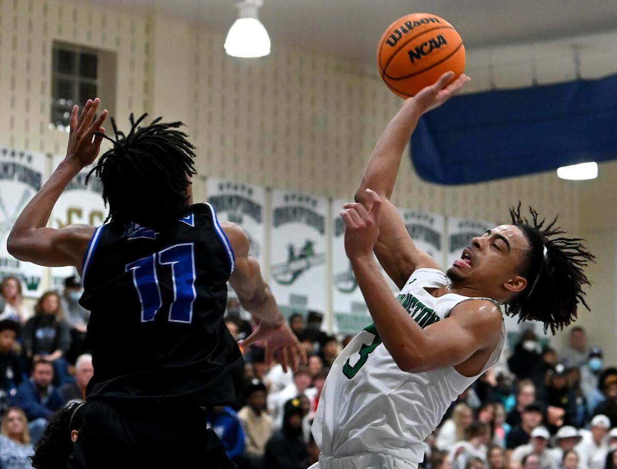 Weddington HighÕs Evan Morton, right, releases a shot over MooresvilleÕs Aishus Stewart, left, during the second round of NCHSAA action on Thursday, February 24, 2022. Weddington is top a top 25 nationally ranked team.