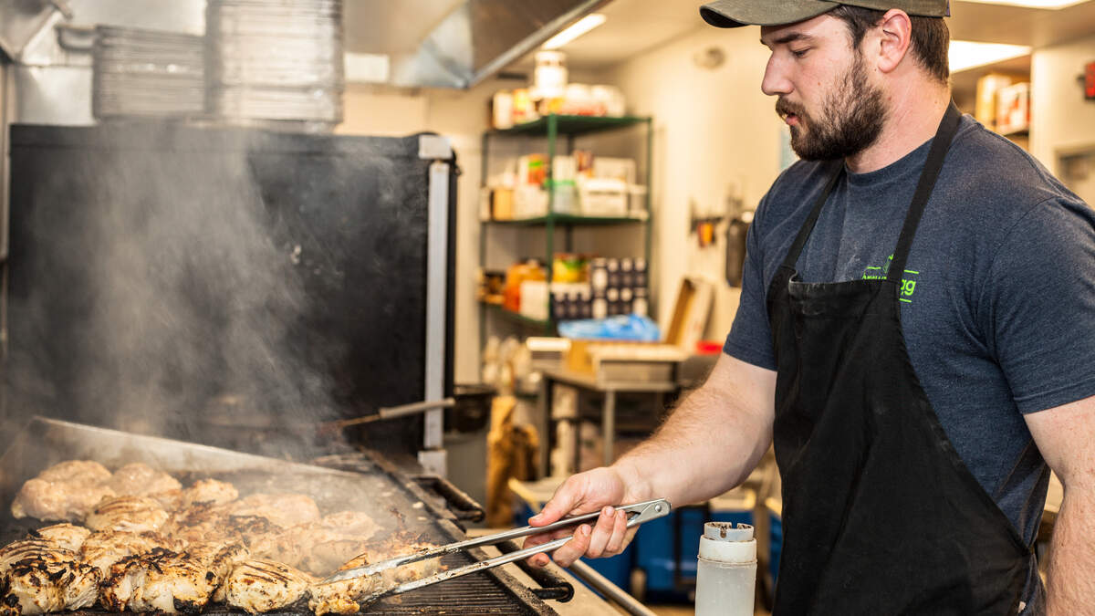 Andrew Howard cooks up chicken in bulk at Brown Bag Charlotte.
