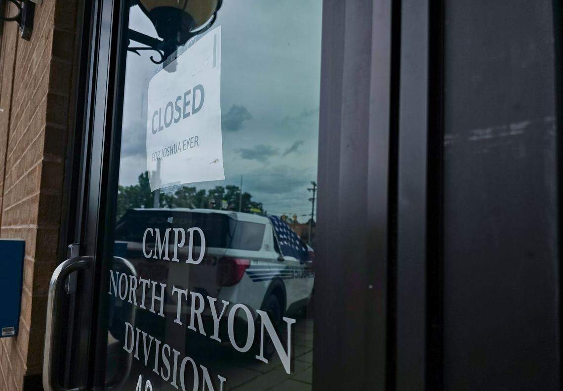 A CMPD officer places a flower bouquet on police vehicle outside police station on N. Tryon Street Tuesday, April 30, 2024. Four officers killed and four wounded when they were serving warrant to the suspect in east Charlotte on Monday, April 29, 2024.