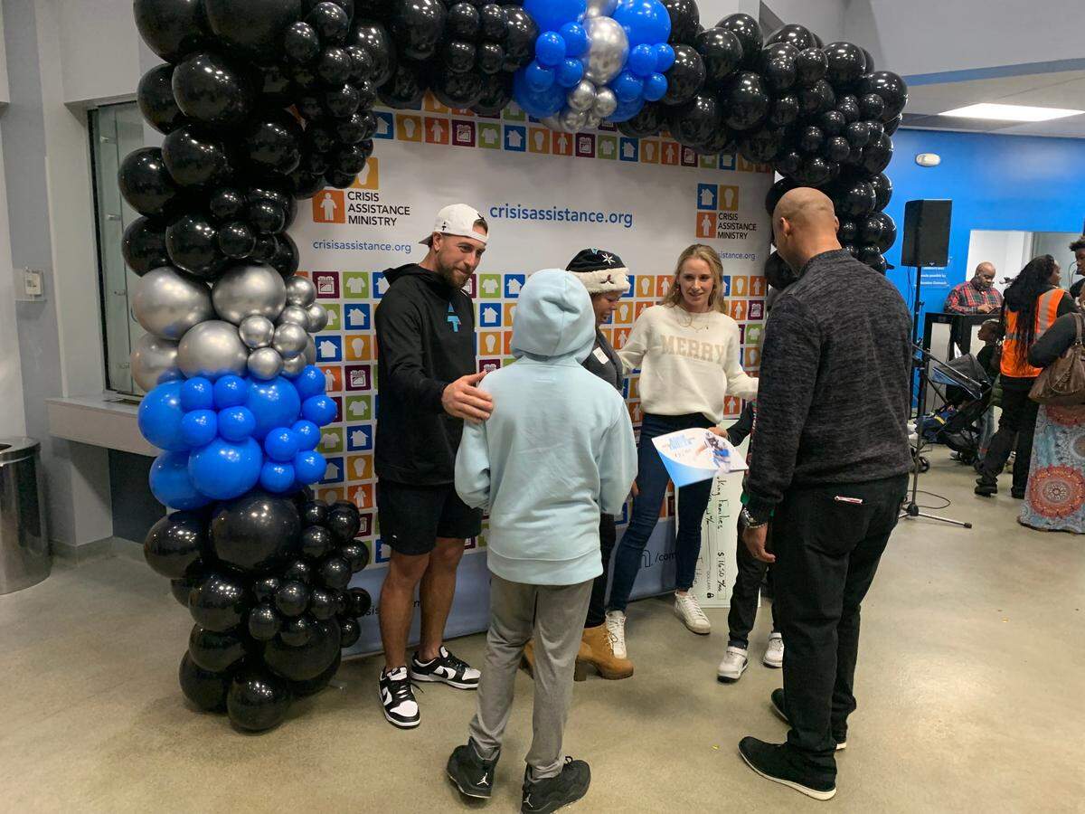 Carolina Panthers WR Adam Thielen and his wife, Caitlin, greet a family at Crisis Assistance Ministry on Thursday, Dec. 19, 2024.