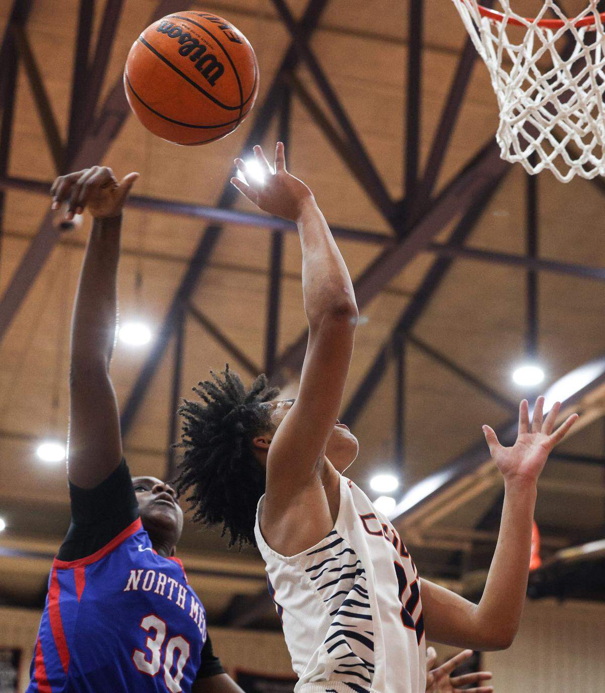 North Meck’s Lenise Joseph, left, taps the ball out of the hands of Chambers’ Lacie Grovner during the game at Chambers High School on Thursday, January 9, 2025.