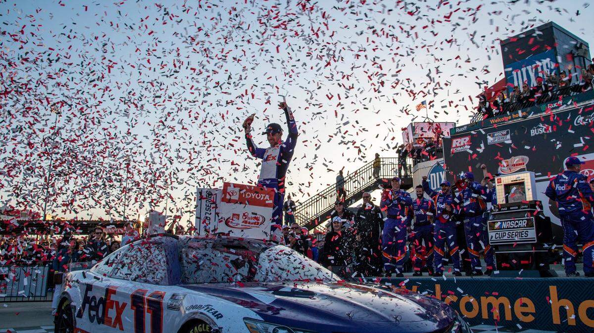Denny Hamlin raises his hands in Victory Lane after winning the NASCAR Cup Series auto race at Richmond Raceway on Sunday, April 3, 2022, in Richmond, Va. (AP Photo/Mike Caudill)