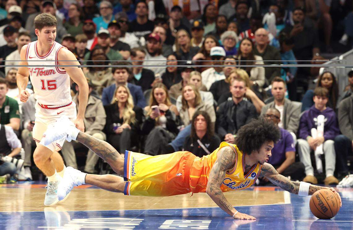 Charlotte Hornets guard Tre Mann, right, dives after a loose ball as Houston Rockets guard Reed Sheppard, left, looks on during action at Spectrum Center in Charlotte, North Carolina, on Feb. 19, 2026.