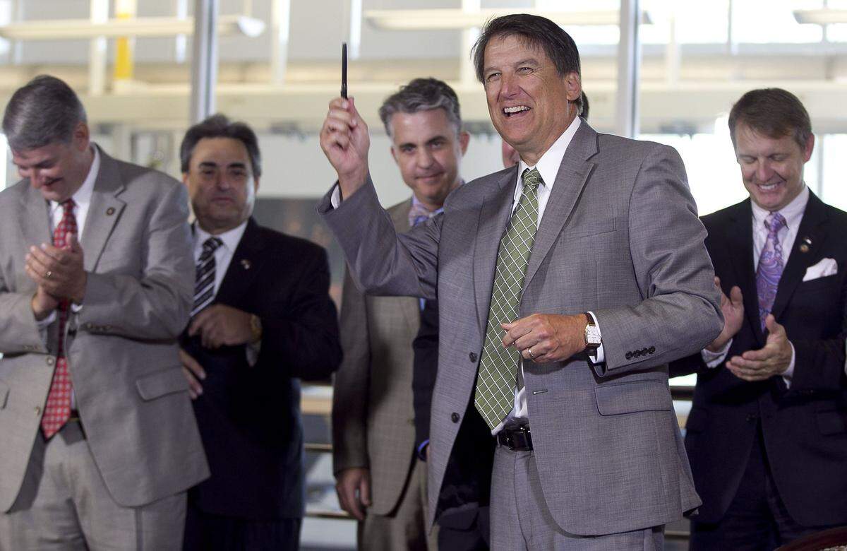 Governor Pat McCrory flanked by (l-r) Senator E.S. Newton, Senator Bob Rucho, Legislative staffer Jeff Warren, and Rep. Mike Hager applaud the governor following a bill signing to allow fracking in North Carolina at the N.C. State Department of Chemical and Biomolecular Engineering on the Centennial Campus in Raleigh, N.C. on Wednesday, June 4, 2014.