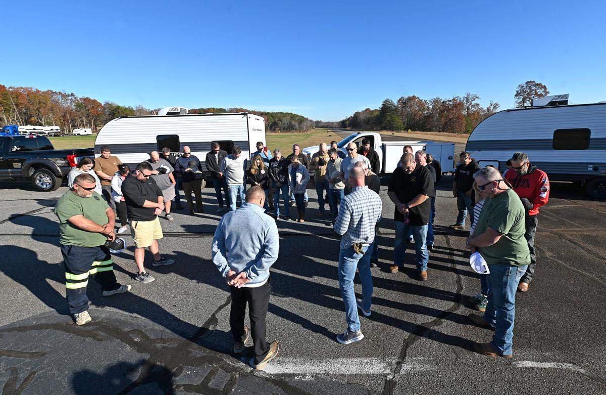 Volunteers gather in prayer prior to leaving the Little Mountain Airport in Maiden with another fleet of campers bound for Western North Carolina on Monday, Nov. 25, 2024. Operation Helo has evolved from rescue missions and has donated more than 100 campers to the more than 300 people who are living in tents around the hardest hit areas of Western North Carolina.