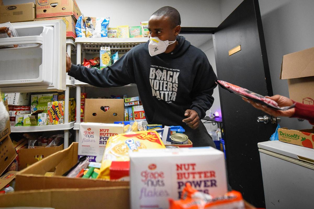 Joshua Bridges, of Charlotte, founder of University Soup Kitchen, works with other volunteers to fill boxes with donated food which will be delivered to people in need at the USK office on North Tryon Street on Feb. 7, 2022.