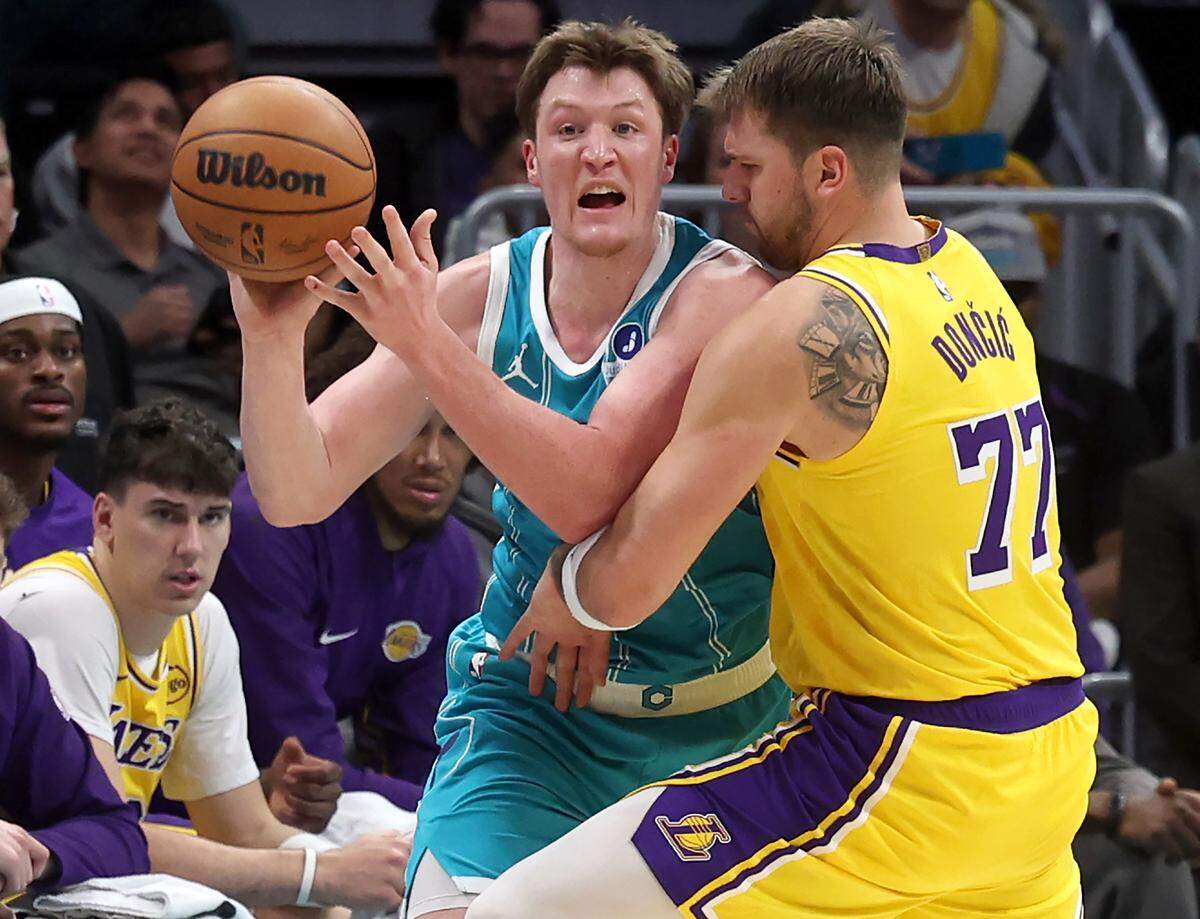 Charlotte Hornets rookie Kon Kneuppel, left, fights to get a pass off to a teammate as Los Angeles Lakers guard Luka Doncic, right, applies defensive pressure during action on Monday at Spectrum Center. The Lakers defeated the Hornets 121-111.