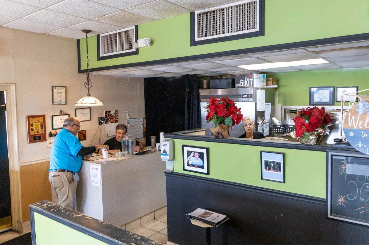 Thrace Bacogeorge, owner of Gus’ Sir Beef, interacts with a guest at the front counter.
