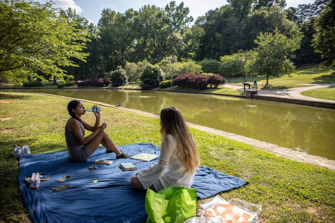 Aniyah Buckner, left, and Stella Ervin sit at Freedom Park in Charlotte on Monday, May 24, 2021. Volunteers canvass throughout Charlotte on July 14 to measure the temperatures of several communities.