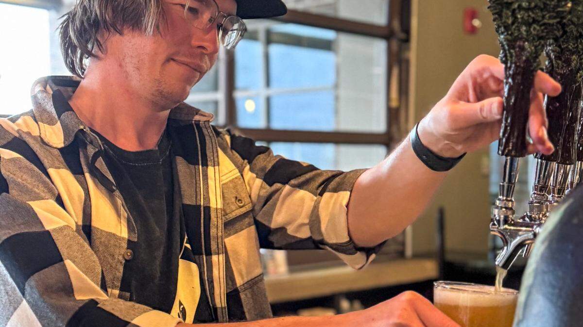 Bartender Mitch Culy pours a glass of beer at Green Man Brewery in Asheville on Jan. 3. Due to fewer customers, the brewery is employing one quarter of its previous workforce at the start of 2025. 