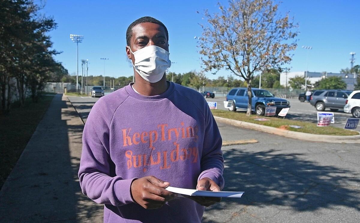 Westley Waters, a formerly incarcerated man who voted for the first time this year, waits to hand out campaign flyers outside the early voting site at Garinger High School on Friday, October 30, 2020.