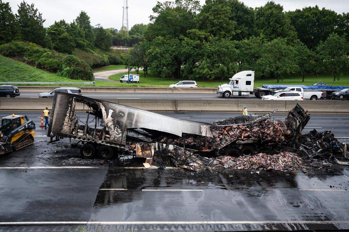 A tractor trailer sits on the side of I-77 northbound after catching on fire early morning on Tuesday, August 16, 2022 in Charlotte, NC.