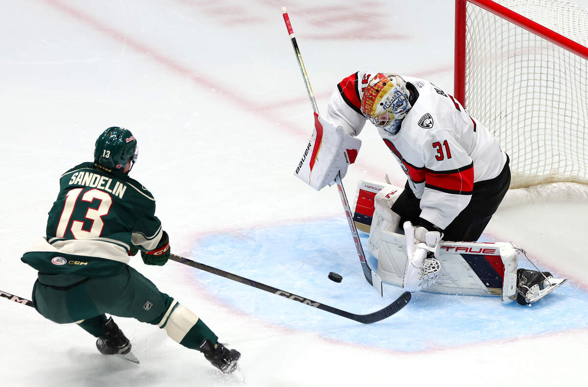 Charlotte Checkers goalie Cooper Black, right, stops a shot on goal by the Iowa Wild’s Ryan Sandelin, left, during first period action on Friday, October 17, 2025 at Bojangles Coliseum in Charlotte, NC.