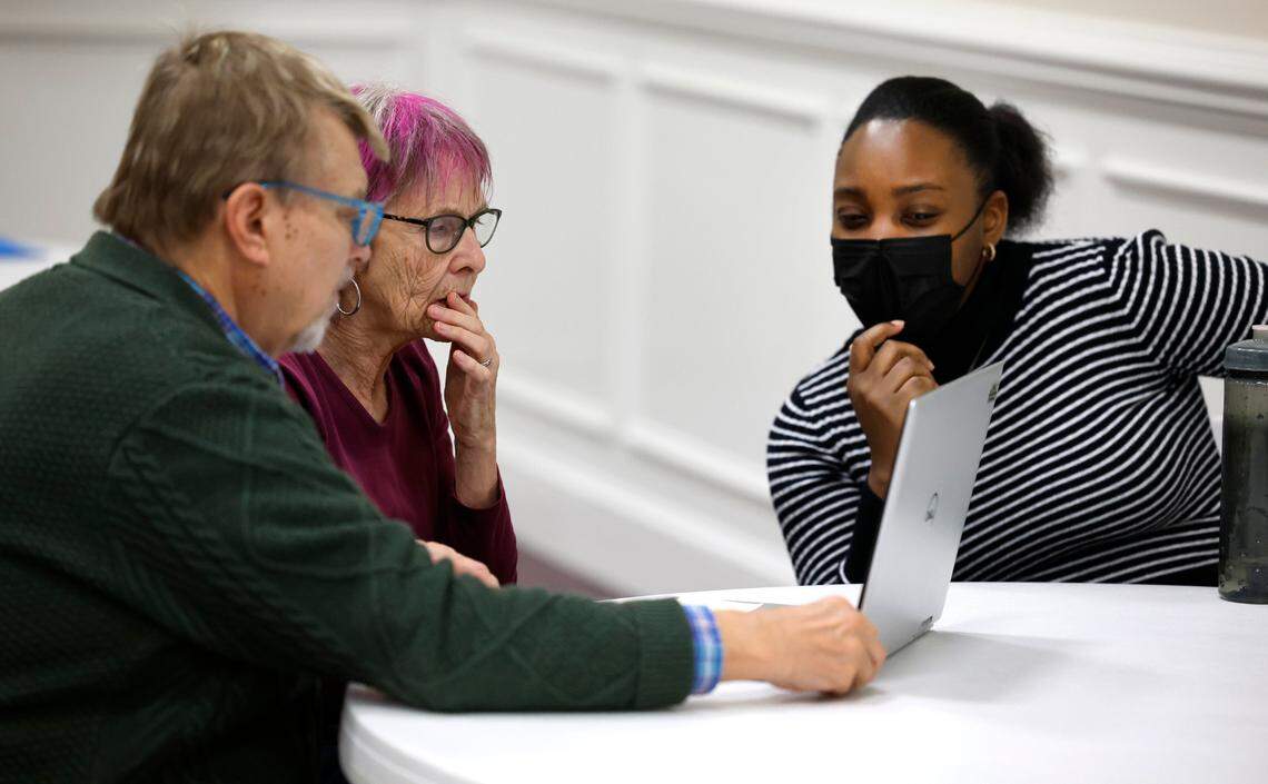 Sammy Surface, left, and his wife Shelagh Boughton, center, work with navigator Shay Hinton during a Wake County ACA and Medicaid enrollment event at Martin Street Baptist Church in Raleigh, N.C., Friday, Dec. 1, 2023.