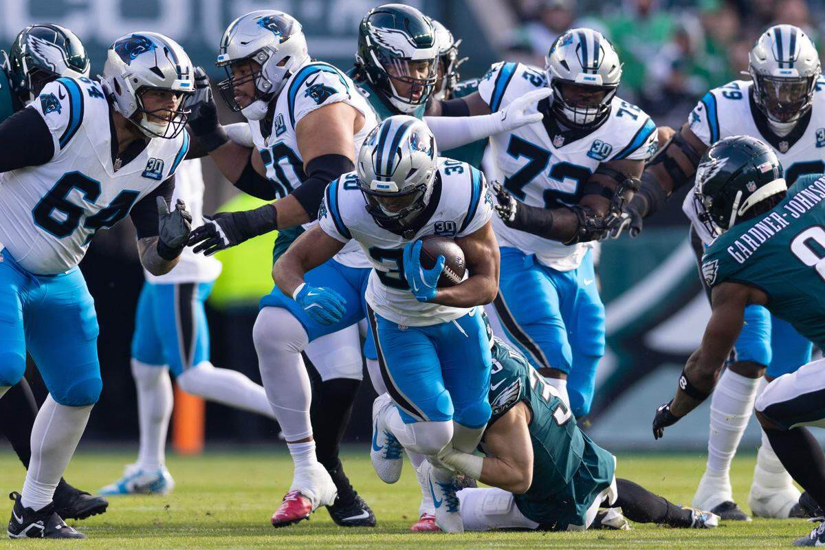 Dec 8, 2024; Philadelphia, Pennsylvania, USA; Philadelphia Eagles cornerback Cooper DeJean (33) tackles Carolina Panthers running back Chuba Hubbard (30) during the first quarter at Lincoln Financial Field. Mandatory Credit: Bill Streicher-Imagn Images