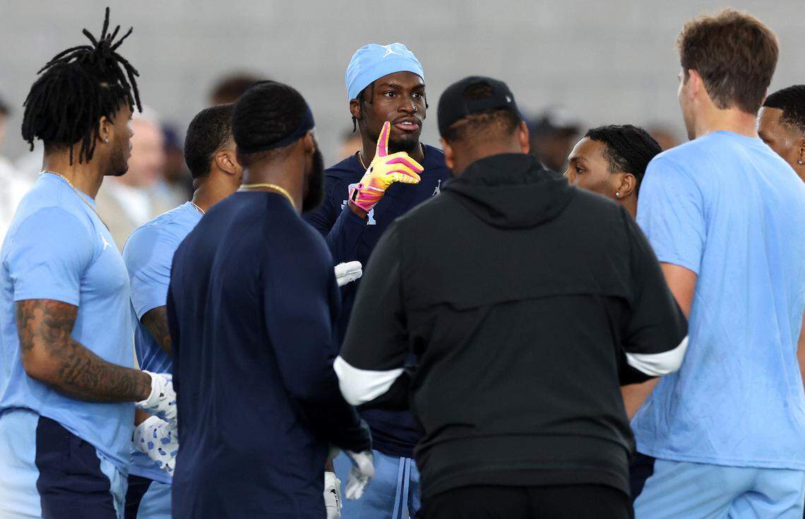 Wide receiver Tez Walker, center, makes a point during a brief huddle at the Carolina Football Pro Day at UNC Chapel Hill’s Koman Indoor Practice Facility on Thursday, March 28, 2024.