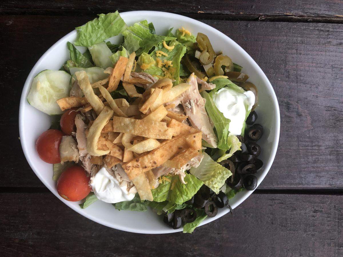 The Rotisserie Salad at the Roasting Company includes cheese, tomatoes, cucumbers, black olives, sour cream, pickled jalapeños, crunchies and pulled rotisserie chicken.