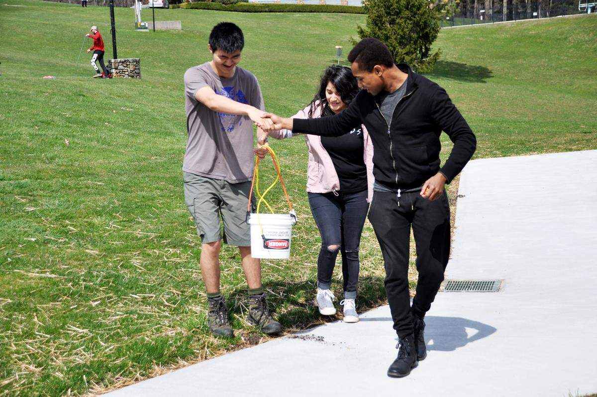 Christopher St. Hilaire, right, leads fellow CPCC students Seth Parrish and Betsy Barron through a team-building activity at Central Piedmont Student Life’s Student Leadership Conference in March 2019.