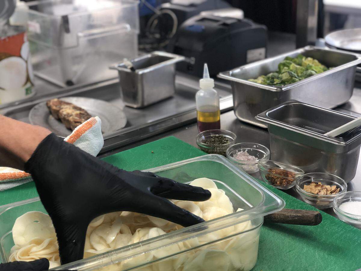 Before boiling parsnips in a saucepan, Charlotte City Club chefs slice them up into paper-thin rounds.