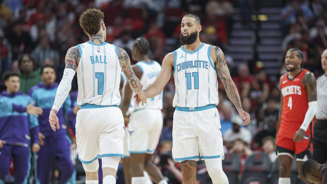Charlotte Hornets forward Cody Martin (11) reacts with guard LaMelo Ball (1) after a play during the first quarter against the Houston Rockets at Toyota Center. 