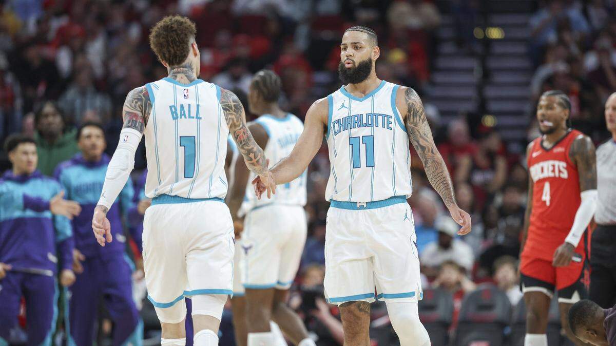 Charlotte Hornets forward Cody Martin (11) reacts with guard LaMelo Ball (1) after a play during the first quarter against the Houston Rockets at Toyota Center. 