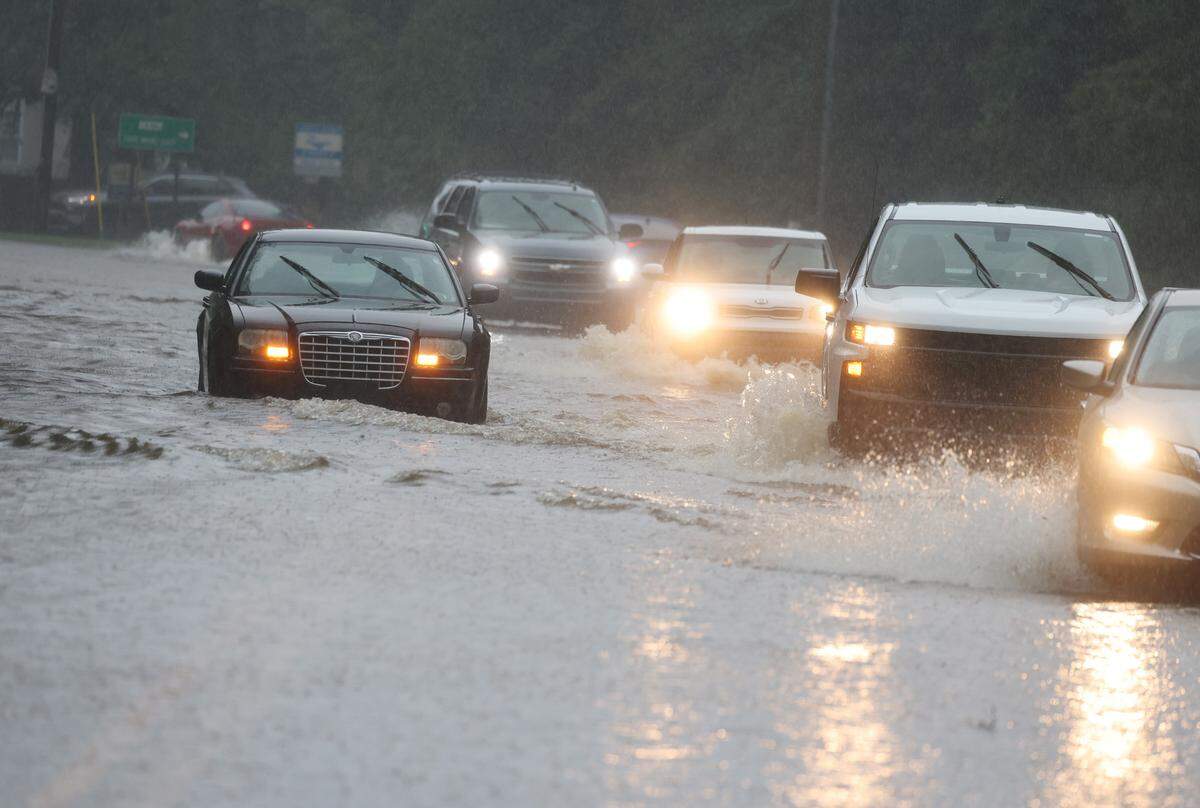 A car stalls in a flooded area at the intersection of Ogden Road and Heckle Blvd. Thursday as Debby dumps inches of rain.