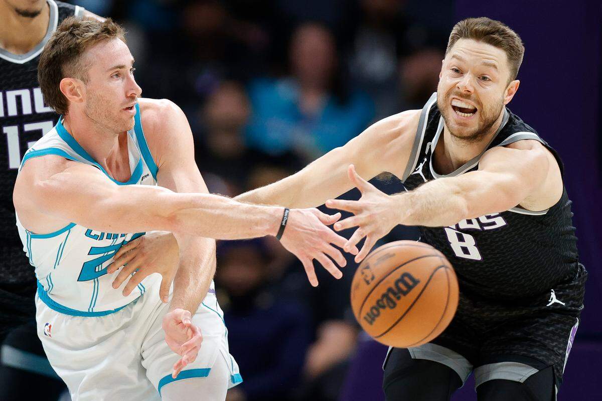 Charlotte Hornets forward Gordon Hayward (20) passes around Sacramento Kings guard Matthew Dellavedova (8) during a game at Spectrum Center in Charlotte, N.C., Monday, Oct. 31, 2022.