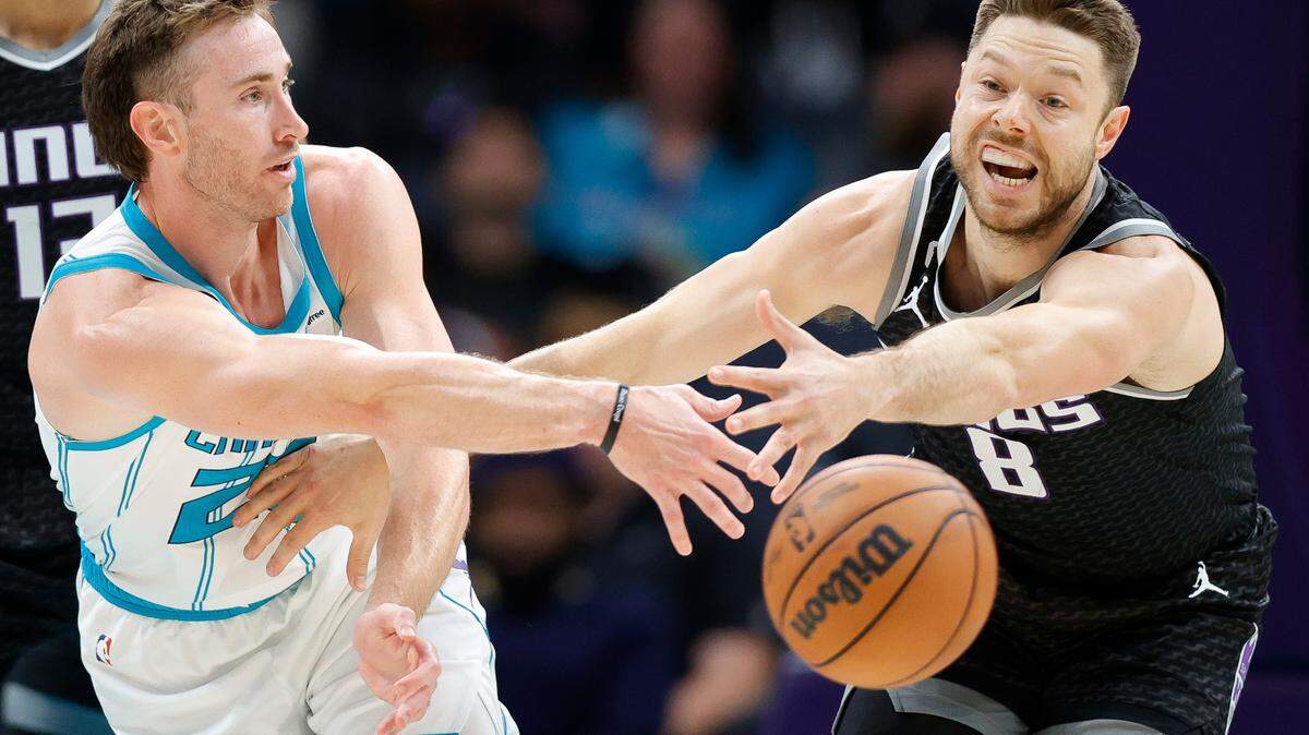 Charlotte Hornets forward Gordon Hayward (20) passes around Sacramento Kings guard Matthew Dellavedova (8) during a game at Spectrum Center in Charlotte, N.C., Monday, Oct. 31, 2022.
