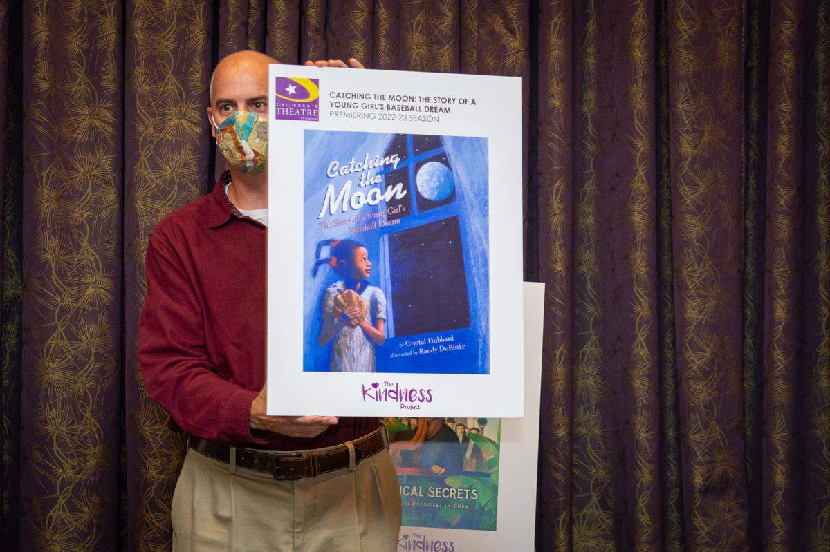 Adam Burke, artistic director of Children’s Theatre of Charlotte, announces “Catching the Moon: The Story of a Young Girl’s Baseball Dream” as the next installment of The Kindness Project.
