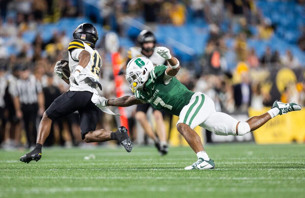Appalachian State Mountaineers wide receiver Jaden Barnes, left, avoids a tackle by Charlotte 49ers defensive lineman DJ Burgess during the Duke's Mayo Classic at Bank of America Stadium in Charlotte, N.C., on Friday, August 29, 2025.