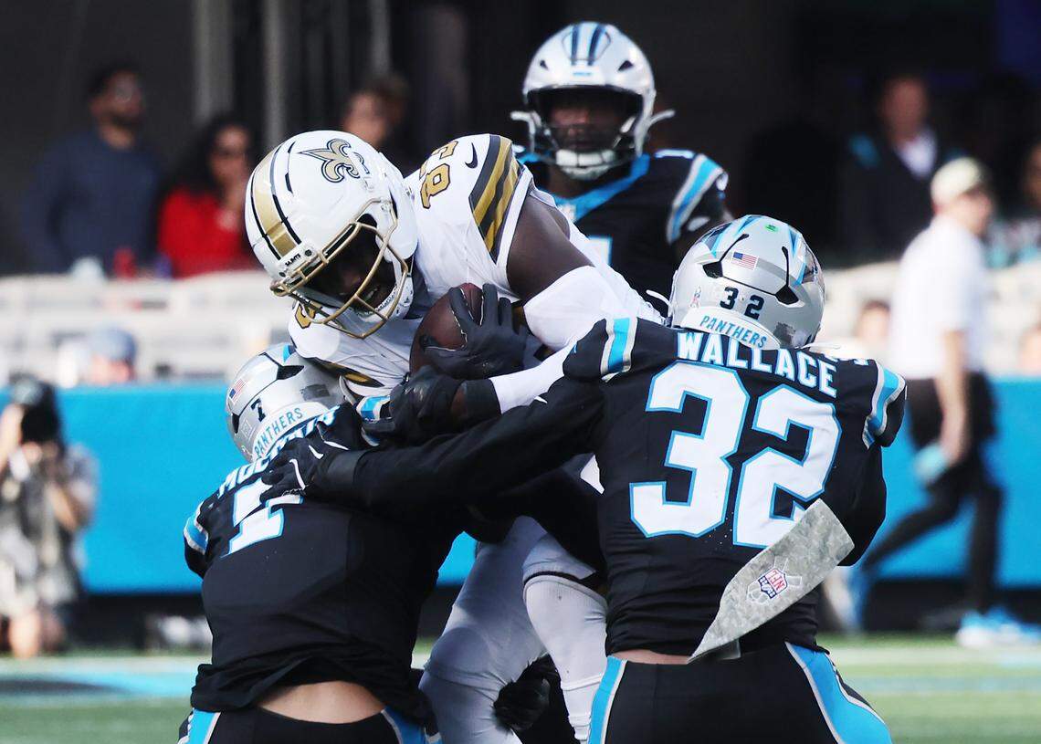 Carolina Panthers Tre'von Moehrig and Trevin Wallace tackle New Orleans' Juwan Johnson on Nov. 9, 2025, at Bank of America Stadium in Charlotte, North Carolina.