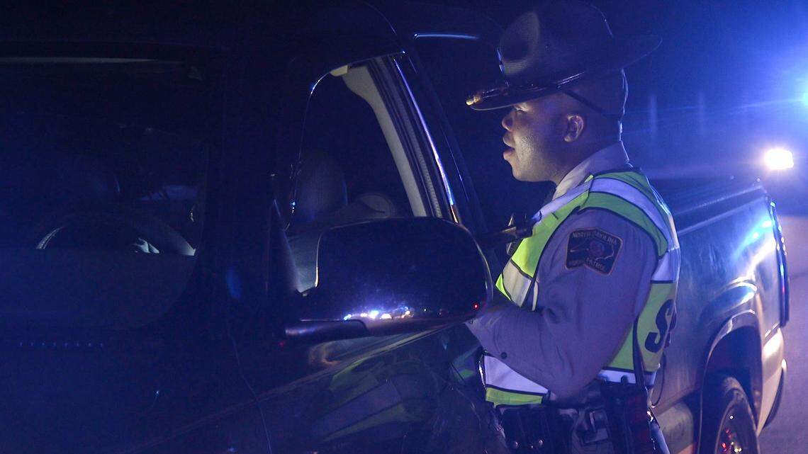 Trooper Charles Montgomery, with the N.C. Highway Patrol, questions a driver at a license checkpoint following the Aug. 29 Panthers game in Charlotte.