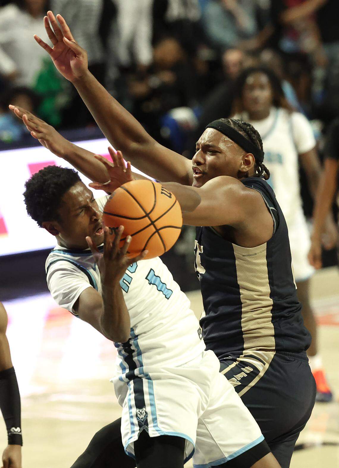Hunter Huss’ O’Brian Lockhart, left, fights to maintain of a rebound as Fike’s Da’qavis Greene, right, rushes in during action in the NCHSAA 5A boys championship game on Saturday, March 14, 2026 at Lawrence Joel Veterans Memorial Coliseum in Winston-Salem, NC.
