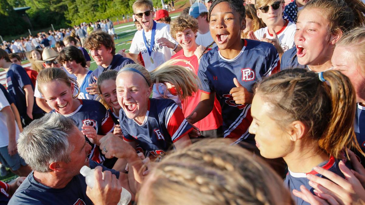 Providence Day coach Dan Dudley, bottom left, celebrates with his team after they defeated Latin 4-3 in Charlotte, N.C., Saturday, May 15, 2021.