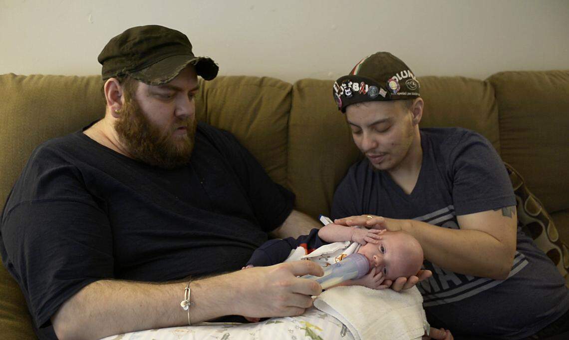 Their first day at home with Cypress, Liam and Duane work together to feed their baby.