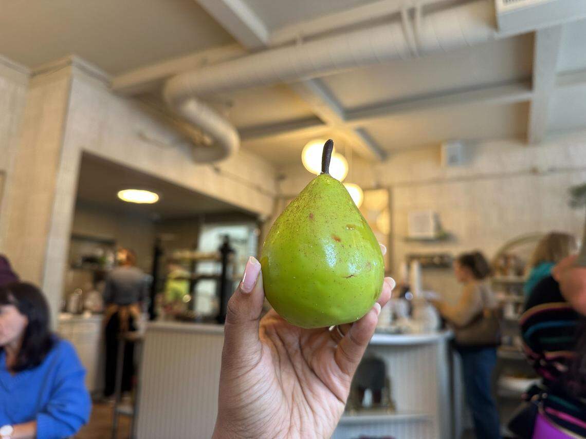 The pear pastry from Daily Grind Coffee Bar in Waxhaw, NC, is a work of edible art, featuring a glossy white chocolate shell and a realistic, chocolate-dipped stem.