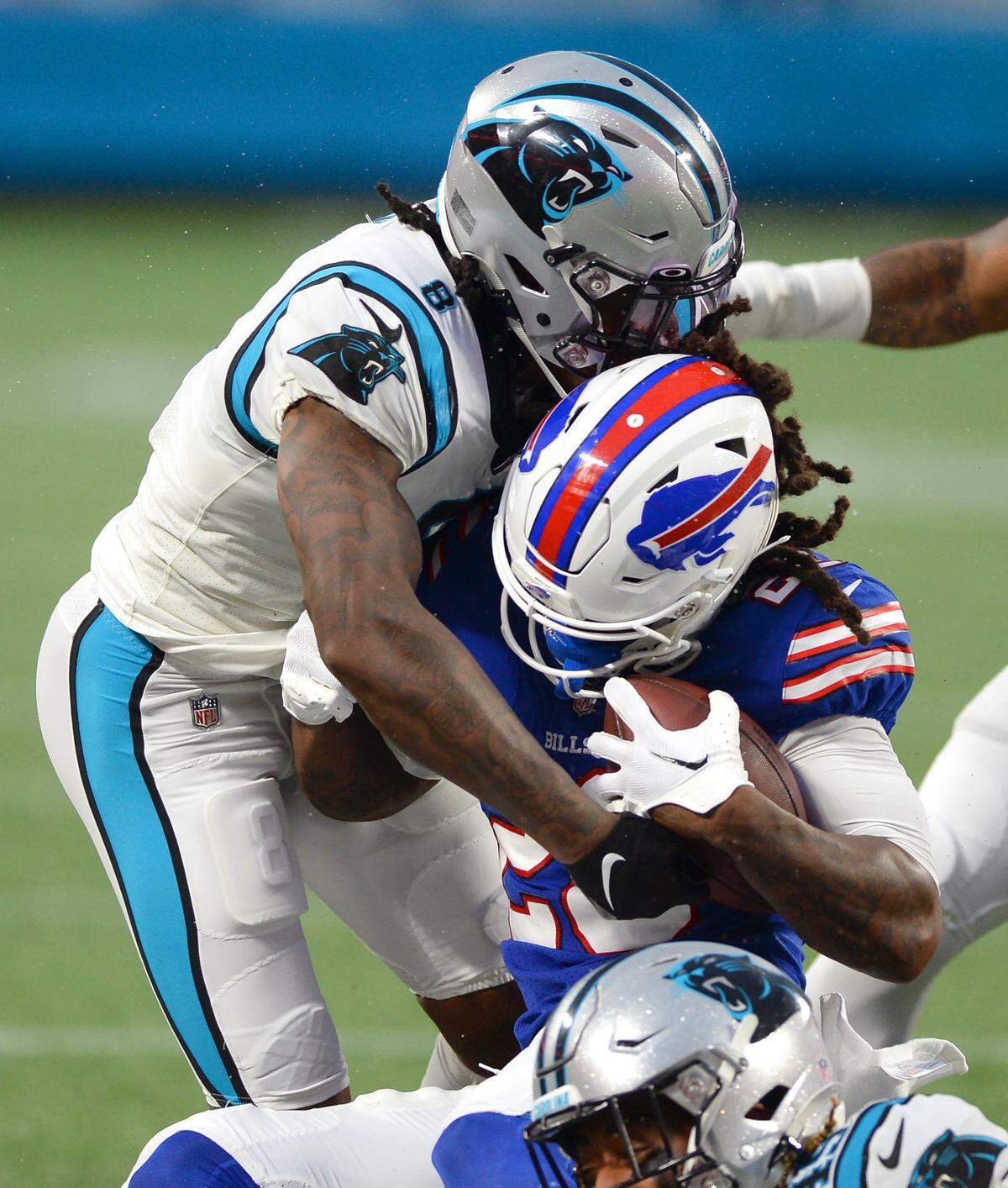 Carolina Panthers cornerback Jaycee Horn, left, makes the tackle on Buffalo Bills running back James Cook, center, during first quarter action at Bank of America Stadium in Charlotte, NC on Friday, August 26, 2022.