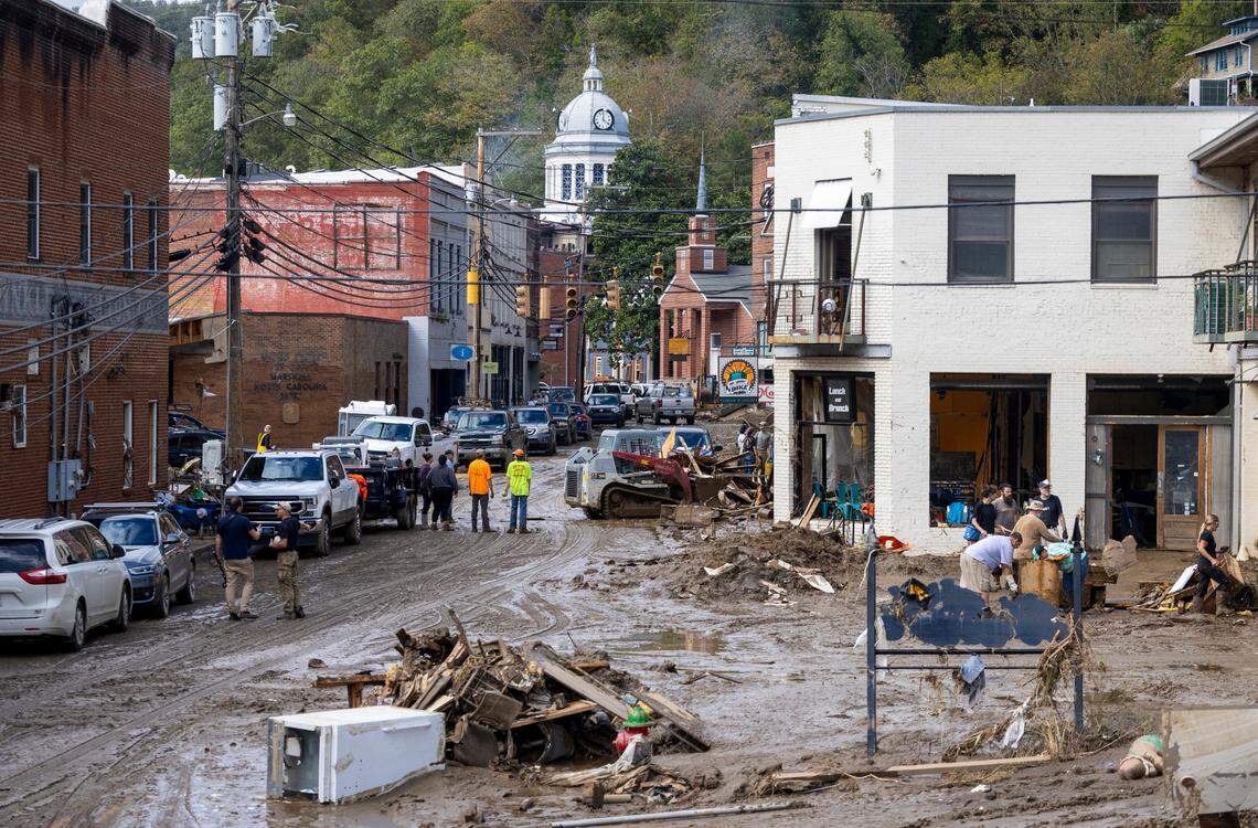 Residents and volunteers clean up on Tuesday, Oct. 1, 2024 after the French Broad River flooded downtown Marshall. The remnants of Hurricane Helene caused widespread flooding, downed trees, and power outages in western North Carolina.