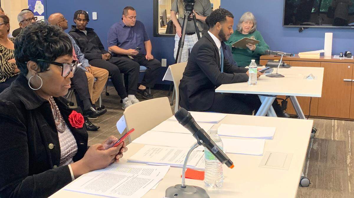 Caleb Theodros and Lucille Puckett await their hearing with the Mecklenburg County Board of Elections on April 23. Puckett is protesting Theodros’ win in the NC Senate District 41 primary.