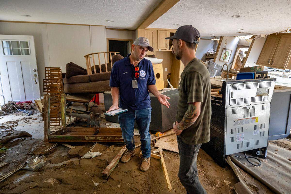 FEMA employee Jirau Alvaro works with Daniel Mancini, doing a report on the damage to his property on Sunday, October 6, 2024 in rural Buncombe County, near Black Mountain, N.C.