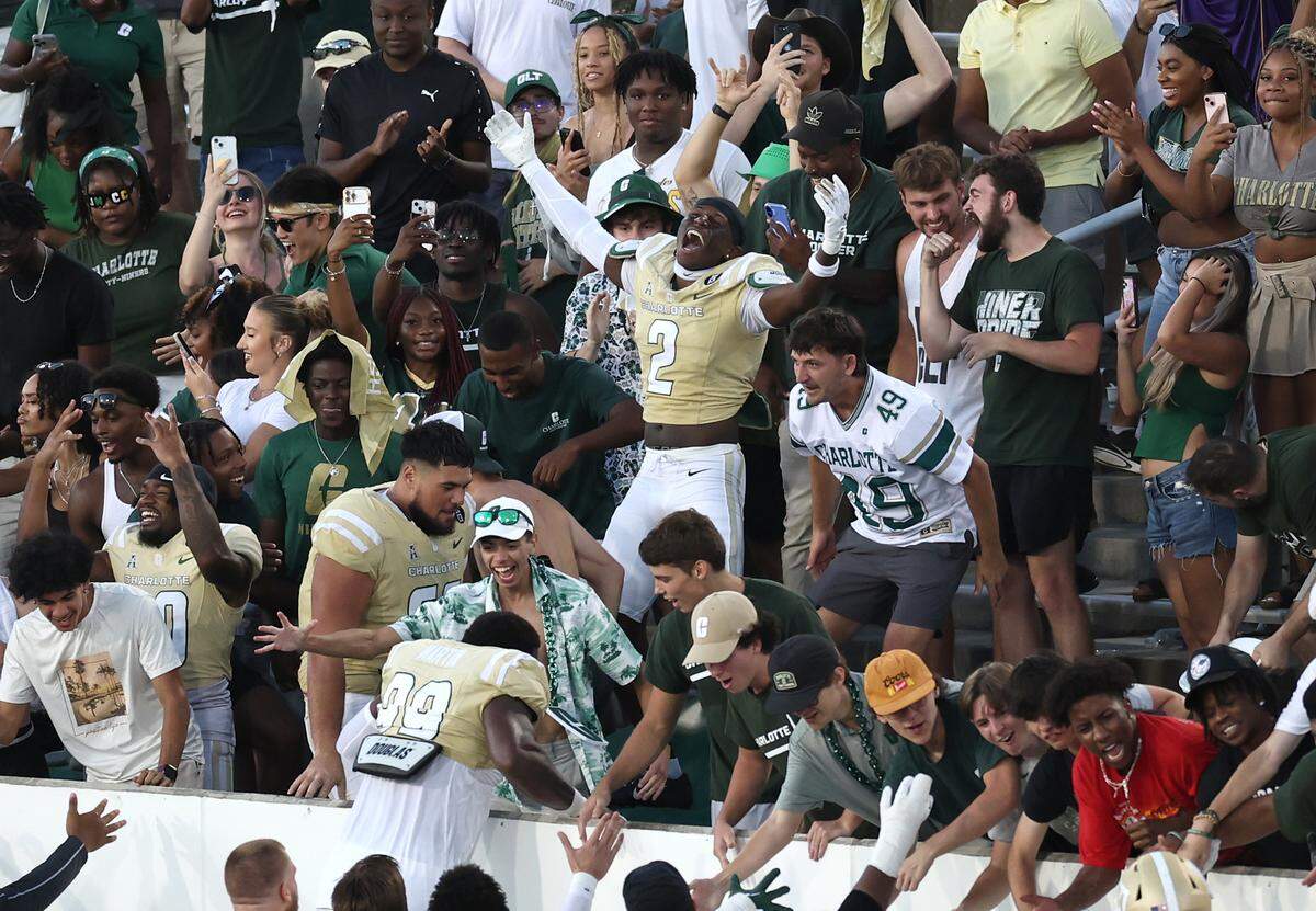 Charlotte 49er’s football players climb into the stands to celebrate the team’s 55-24 victory over the East Carolina Pirates on Saturday, October 5, 2024 at Jerry Richardson Stadium in Charlotte, NC.