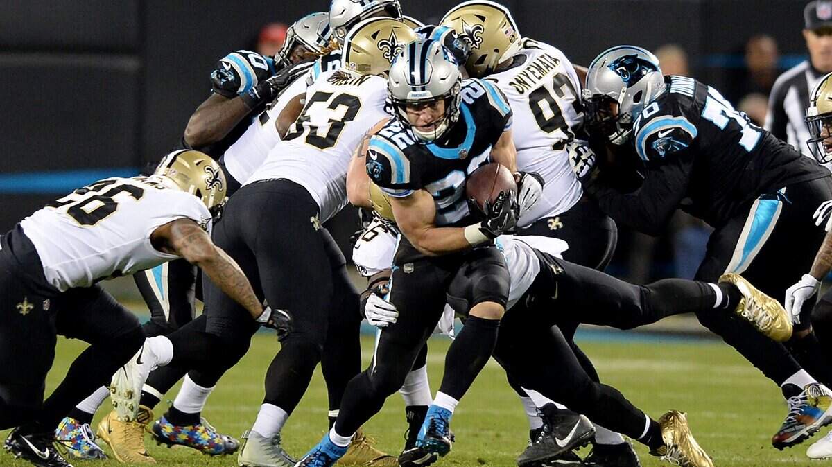 Carolina Panthers running back Christian McCaffrey (center) breaks through a hole in the New Orleans Saints defense during first quarter action on Monday.